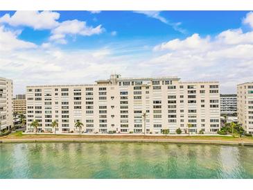 Waterfront condo building featuring multiple stories, balconies, and lush landscaping in a picturesque setting at 6020 S Shore Blvd # 709, Gulfport, FL 33707