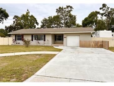 Charming single-story home featuring a well-maintained lawn and a paved driveway leading to an attached garage at 1233 Belleair Rd, Clearwater, FL 33756