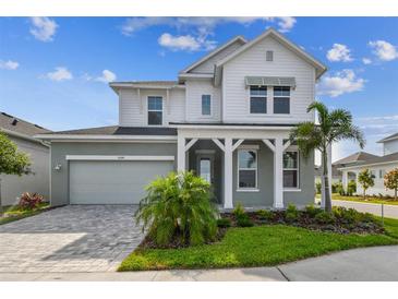 Charming two-story home with manicured lawn, lovely landscaping and a welcoming front porch at 1586 Running Tide Pl, Sarasota, FL 34240