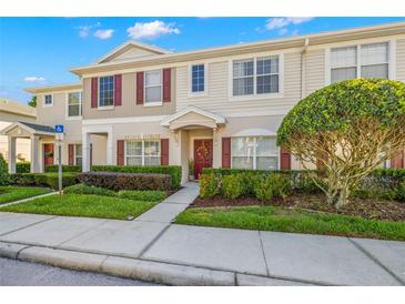 Charming two-story townhouse with red shutters, landscaped yard, and inviting entrance at 1749 Sedgefield Ct, Odessa, FL 33556
