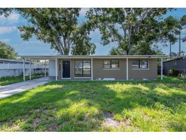 Cozy single-story home featuring a covered carport and quaint front yard at 2004 Windsor Way, Tampa, FL 33619