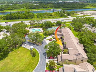 A top-down view showing community amenities and property location near the river and highway at 3044 Red Oak Ct # 204, Palm Harbor, FL 34684