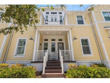 Charming yellow townhome with inviting front porch and well-maintained landscaping at 340 Sapphire Lake Dr # 202, Bradenton, FL 34209