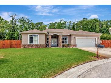 Charming single story home with a lush green lawn and an attached two car garage at 10305 Worthy Lamb Way, New Port Richey, FL 34654
