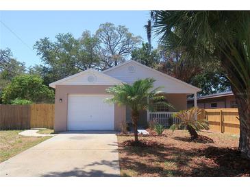 Charming single-story home featuring a one-car garage, well-maintained lawn, and tropical landscaping at 1344 S Michigan Ave, Clearwater, FL 33756