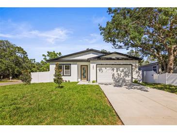 Charming single-story home with a well-manicured lawn, attached garage, and classic white exterior at 331 Archimedes St, Dunedin, FL 34698