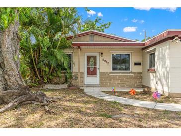 Charming single-story home with well-kept lawn, large tree, and inviting front entrance with colorful decorations at 6982 78Th N Ave, Pinellas Park, FL 33781
