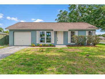 Charming one-story home with a well-manicured lawn, attached garage, and shuttered windows at 7400 Belvedere Ter, New Port Richey, FL 34655