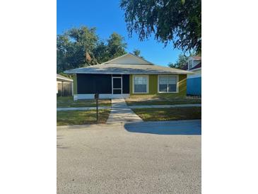 Charming single-story home with a green lawn and an enclosed front porch at 10411 Summerview Cir, Riverview, FL 33578