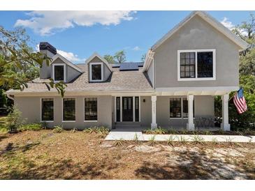 Charming two-story home with black-trimmed windows, pillars, and a landscaped front yard at 11207 Donneymoor Dr, Riverview, FL 33569