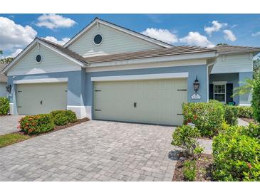 Charming home with a two-car garage and well-maintained landscaping featuring bushes and a paved driveway at 12817 Cobalt Ter, Bradenton, FL 34211