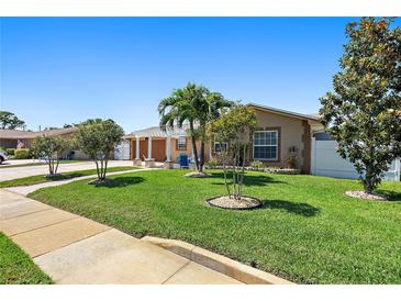 Charming single-story home featuring a lush lawn with beautiful landscaping and curb appeal at 13035 91St Ave, Seminole, FL 33776