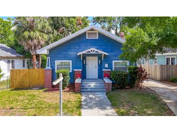 Charming blue bungalow with a welcoming front porch and well-manicured lawn, offering classic curb appeal at 207 W Chelsea St, Tampa, FL 33603