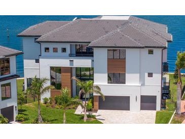 Beautiful modern waterfront home featuring a two-car garage, well-maintained lawn, and lush palm trees at 2087 Michigan Ne Ave, St Petersburg, FL 33703