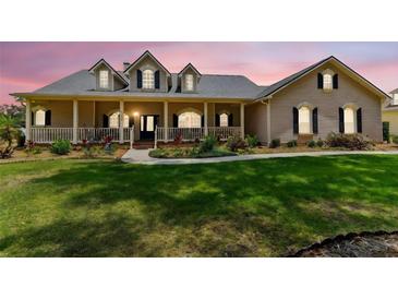 Charming single-Gathering home featuring a covered front porch, inviting curb appeal, and lush landscaping at 2202 Colewood Ln, Dover, FL 33527