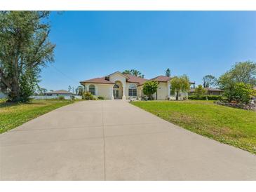 Sprawling single-story home with long driveway, manicured lawn and mature landscaping at 3610 Woodbridge Ave, North Port, FL 34287