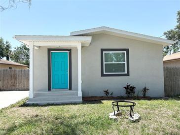 Charming single-story home boasts a striking turquoise door and freshly landscaped front yard at 3708 N 56Th St, Tampa, FL 33619