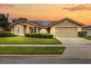 Charming single-story home with a well-maintained lawn, solar panels and a two-car garage at sunset at 5405 El Cerro Dr, New Port Richey, FL 34655