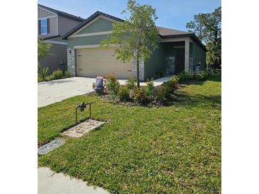 Charming single-story home with a well-manicured lawn and a two-car garage at 10607 Ladybug Cv, Parrish, FL 34219