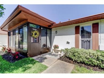 Inviting front entrance with enclosed porch, decorative wreath, and well-maintained landscaping at 2380 Shelly Dr # B, Palm Harbor, FL 34684