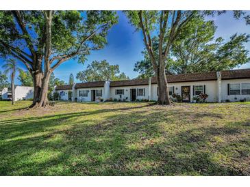 Charming townhomes surrounded by mature trees and a well-maintained lawn offering curb appeal at 3126 Highlands Blvd # 3126, Palm Harbor, FL 34684