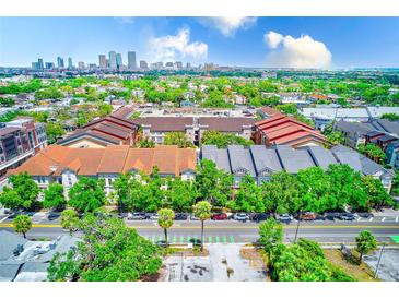 Beautiful aerial view of townhomes with a lovely landscape and Tampa skyline in the background on a sunny day at 402 S Armenia Ave # 139A, Tampa, FL 33609