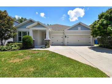Charming single-Gathering home with a well-manicured lawn and a two-car garage under a sunny sky at 4918 Lakeshore Oaks Ct, Tampa, FL 33624