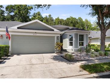 Charming single Gathering home with a two-car garage, landscaped front yard, and an American flag displayed at 8562 Acorn Ridge Ct, Tampa, FL 33625