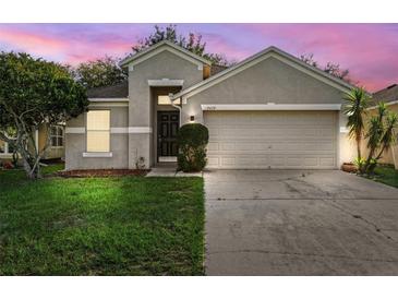 Charming single-story home featuring a well-maintained lawn and an attached two-car garage at 9479 Southern Charm Cir, Brooksville, FL 34613