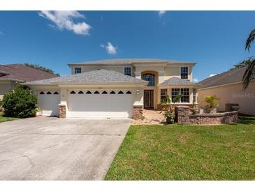 Charming two-story home featuring a three-car garage, landscaped yard, and beautiful architectural details at 10522 Sky Flower Ct, Land O Lakes, FL 34638