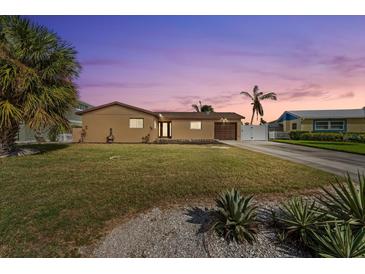 Charming single-story home featuring a well-manicured lawn and mature palm trees at 5108 Commonwealth Rd, Palmetto, FL 34221