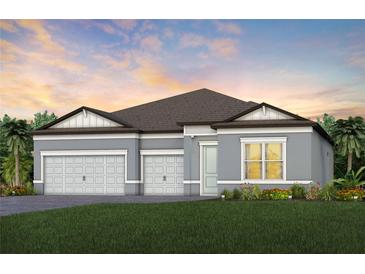 Charming single-story home featuring a three-car garage, and beautifully landscaped front yard with colorful flowers at 6811 Jared Oaks Dr, Wesley Chapel, FL 33545