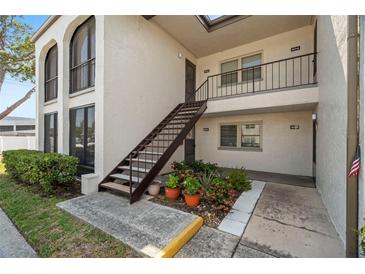 Condo exterior featuring a private entrance with stairs and well-maintained landscaping at 7701 Starkey Rd # 601, Seminole, FL 33777