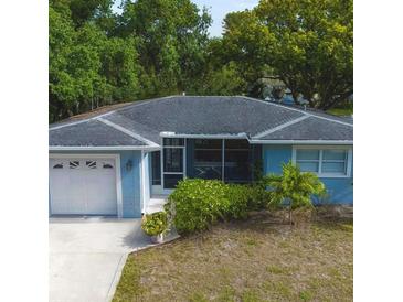Charming home featuring a one-car garage, screened porch, and lush landscaping at 10980 104Th Ave, Largo, FL 33778