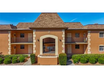 Inviting two-story condo building featuring warm paint, tidy landscaping and a prominent letter 'D' at 12900 Vonn Rd # D202, Largo, FL 33774