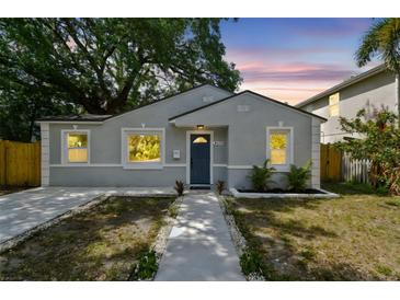 Charming bungalow-style home with blue door, fresh landscaping, and a welcoming walkway to the entrance at 2230 Melrose S Ave, St Petersburg, FL 33712