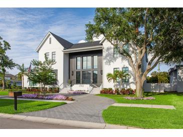 Elegant two-story home showcasing a well-maintained lawn and modern gray and white design elements at 2902 S Beach Dr, Tampa, FL 33629