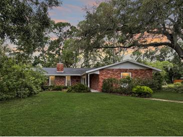 Charming brick home with a well-manicured front lawn and mature trees at 5901 3Rd S St, St Petersburg, FL 33705