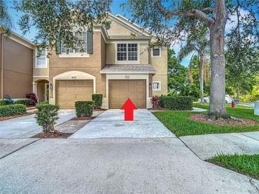 Two story townhome with attached garages and a well maintained lawn and landscaping at 8576 Sandy Beach St, Tampa, FL 33634