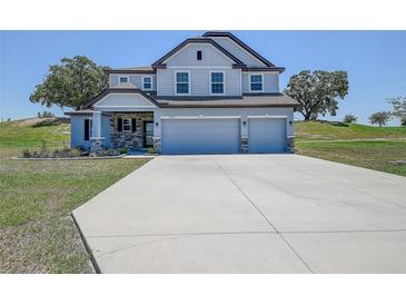 Charming two-story home featuring a three-car garage and stone accents at 10517 Crestview Heights Ave, Thonotosassa, FL 33592