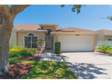 Charming single-story home with manicured lawn, a two car garage and inviting front porch at 1126 Haley Ln, Dunedin, FL 34698