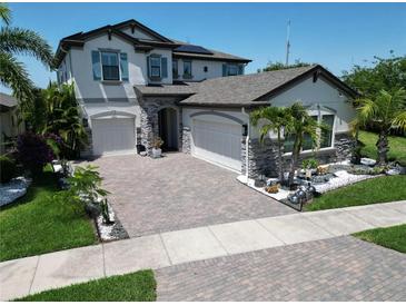 Beautiful two-story home with a well-manicured front yard and a three car garage at 13103 Monach Isles Dr, Riverview, FL 33579