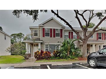 Charming townhome featuring red shutters, tasteful landscaping, and a welcoming entrance at 13640 Forest Lake Dr, Largo, FL 33771