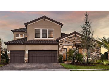 Beautiful two-story home featuring a brick and stucco facade, and a two-car garage at 13726 Heartwood Way, Parrish, FL 34219
