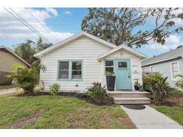 Charming home with a white exterior, light blue door, and well-maintained landscaping at 2015 3Rd S St, St Petersburg, FL 33705