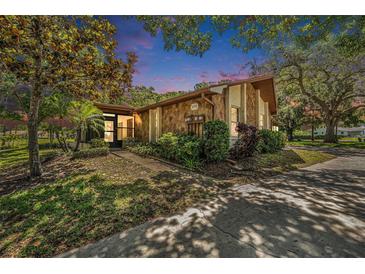 Charming single-story home featuring a stone facade, lush landscaping, and a well-maintained lawn at 2770 Keats Ter # C, Palm Harbor, FL 34684