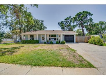 Charming single-story home with a well-manicured lawn, attached garage and mature trees at 4700 Chancellor Ne St, St Petersburg, FL 33703