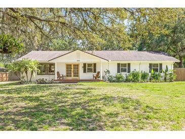 Charming single-story home with a well-manicured lawn and mature trees providing ample shade at 4805 E Regnas Ave, Tampa, FL 33617