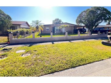 Cozy single-story home featuring a well-maintained lawn and decorative fence at 4812 Bonita Vista Dr, Tampa, FL 33634