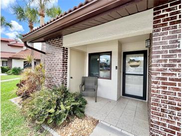 Inviting front porch with tile flooring, accent brick and chair at 7360 Ulmerton Rd # 16A, Largo, FL 33771